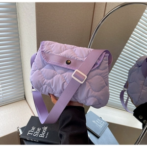 Macro detail of lavender quilted shoulder bag with wavy stitching and adjustable strap