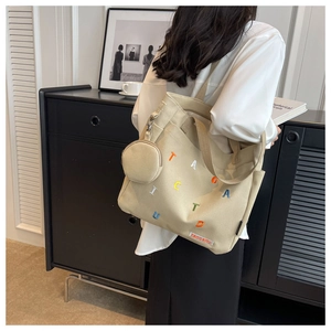 Detail of canvas tote bag with colorful letter embroidery and mini round coin purse