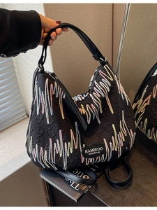 Large black handbag with colorful wave embroidery and textured embossed fabric detail