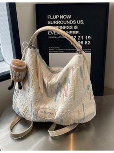 Quilted cream tote bag with colorful embroidery and a cute biscuit plush charm