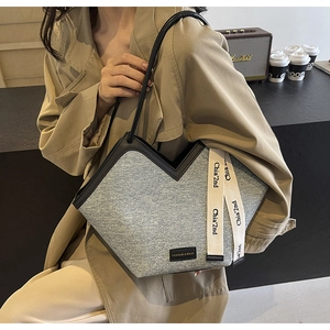 Détail du sac cabas en denim bleu avec ouverture en V et ruban en toile élégant