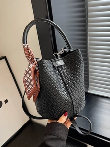 Chic black woven bucket bag with silk scarf handle and adjustable shoulder strap