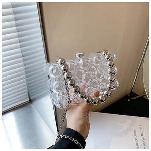 Detailed close-up of a clear bubble texture evening bag with silver metal chain strap