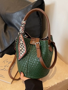 Green woven bucket bag with brown leather strap and silk scarf detail for women