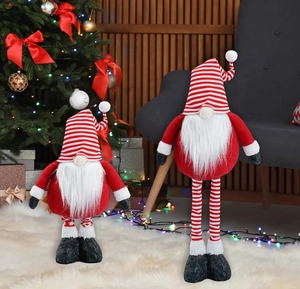 Detail of Nordic Christmas gnomes with striped hats and plush beards by the Xmas tree