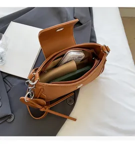 Vista dall'alto di una borsa a tracolla marrone vintage con scomparti per telefono e portafoglio