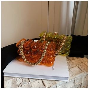 Macro detail of acrylic beaded handbags with cylindrical bubble texture and gold chain straps