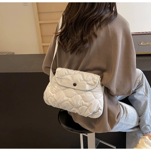 White quilted puffer crossbody bag with a wide strap shown on model for daily style