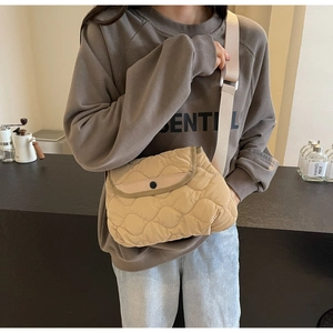 Detail of beige quilted crossbody bag with wave stitching and wide adjustable strap