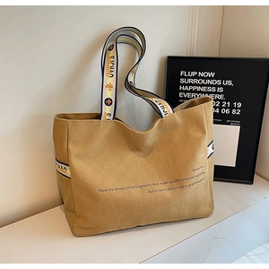 Detail of camel canvas tote bag with thick fabric texture and patterned shoulder strap
