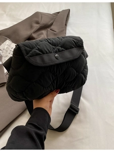 Quilted black puffer crossbody bag with wave texture and adjustable shoulder strap