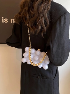 Chic white bubble texture crossbody bag with gold chain and beaded handle on black blazer