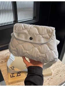 Light grey quilted puffer shoulder bag with wave stitching and adjustable strap