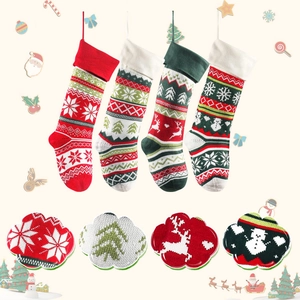 Detailed view of four knitted Christmas socks showing snowflake and reindeer patterns
