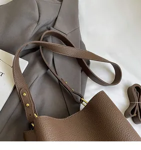 Detail der braunen Ledertasche mit Kieselmaserung und verstellbarer goldener Schnalle