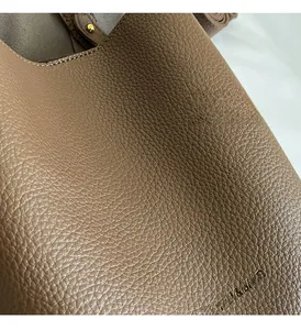 Nahaufnahme der braunen Bucket Bag aus Leder mit Litschimaserung und Logoprägung