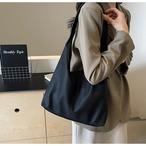 Close-up of black leather tote bag with lychee texture and slouchy hobo design