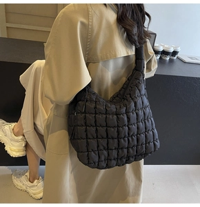 Black quilted puffer hobo bag on shoulder showing large capacity and puffy texture