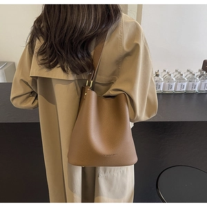Detailansicht braune Eimer-Tasche mit Lychee-Narbenleder und goldenen Metallring-Details