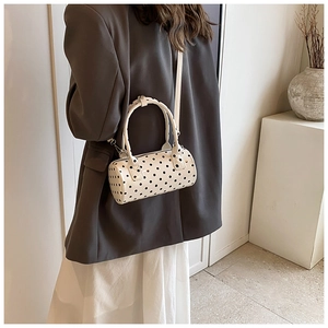 Polka dot cylinder shoulder bag styled with a grey blazer for a modern fashion look