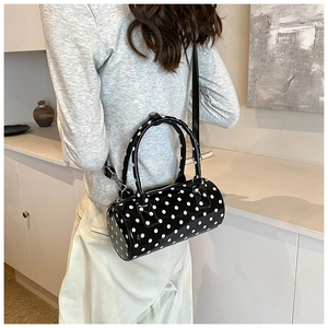 French style polka dot Boston handbag with shiny finish shown on model in a minimal setting