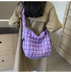 Model view of a purple quilted puffy tote bag featuring large capacity and soft texture