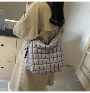 Close-up of quilted puffy lavender tote bag worn with a classic autumn trench coat