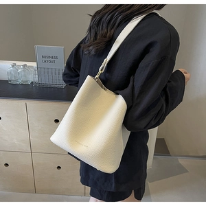 Weiße Bucket Bag aus genarbtem Leder mit breitem Schultergurt und goldenen Beschlägen