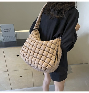 Detail of quilted puffy tote bag with soft texture and beige block pattern finish