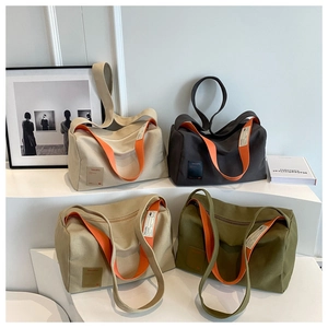 Collection of large canvas tote bags in four colors with orange contrast straps and leather tags