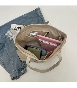 Interior view of large beige canvas tote bag with multi-layer pockets for tablet and daily items