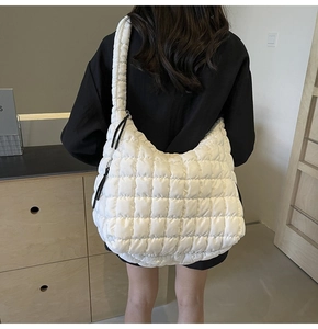 Detailed view of white quilted puffer tote bag showing textured soft fabric and padding