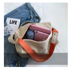 Top view of beige canvas crossbody bag showing large interior capacity with a blue umbrella