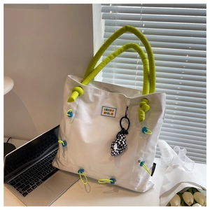 Detail view of large tote bag with KEEP SMILE patch and green padded handles