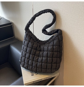 Detail of the black quilted bubble tote bag with soft puffy texture and hobo style shape