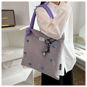 Gray nylon tote bag with purple padded handles and colorful KEEDS SMILE patch