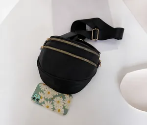 Size comparison of black nylon saddle bag with dual gold zippers and fashion strap