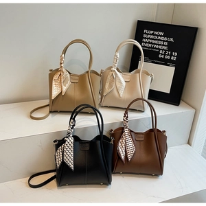 Macro detail of leather bucket bags with knotted silk scarves in four trendy colors