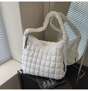 Detail view of white quilted bubble tote bag made of lightweight nylon with zipper