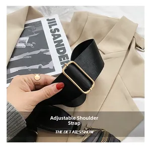 Close-up of adjustable black nylon shoulder strap with a polished gold metal buckle