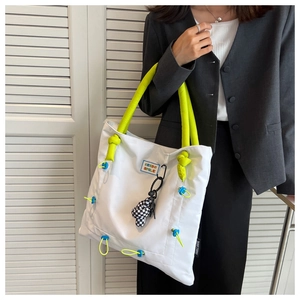 White nylon tote bag featuring neon green padded handles and checkered charm detail