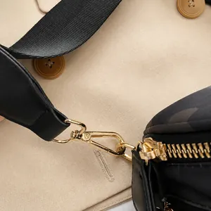 Close-up of golden metal hooks and high-quality zipper on camouflage saddle bag details