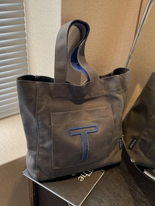 Large gray canvas tote bag with blue embroidered letter T for daily commute