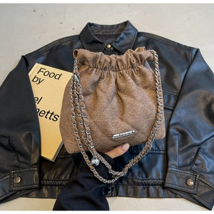 Detailed view of the quilted denim texture and silver chain strap on the bucket bag