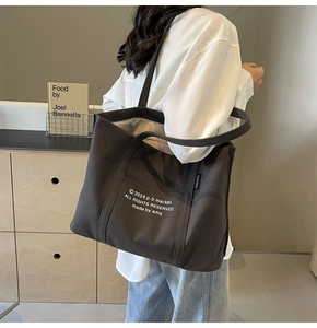 Detail of minimalist canvas tote bag with letter print and durable shoulder strap