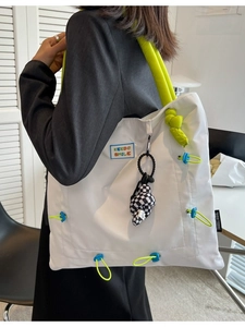 Modern white nylon tote bag with neon green strap and KEEDO SMILE patch shown on model