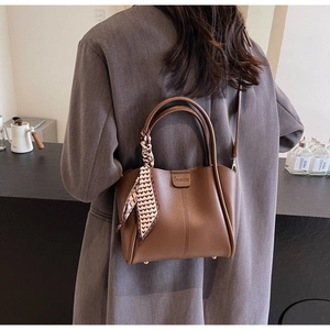 Brown vintage bucket bag with decorative heart print silk scarf on the handles