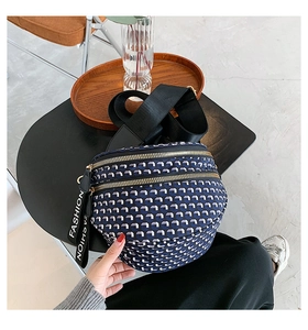 Close-up of geometric pattern saddle bag with double zippers and fashion strap detail