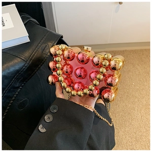 Pink acrylic evening clutch detail showing bubble texture and gold metal chain strap