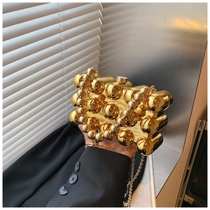 Macro detail of luxury golden acrylic evening bag with spherical modular design and chain